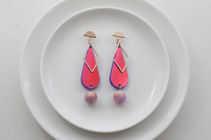 HB Mila teardrop statement earrings arranged on a white plate