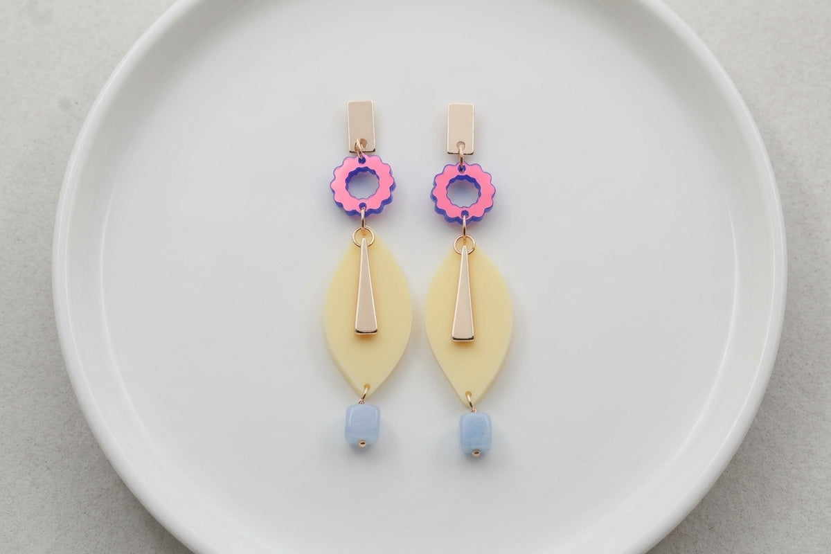 HB Nia long geometric statement earrings arranged on a white plate