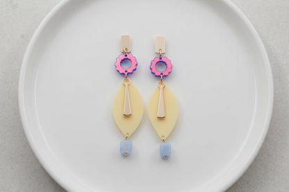 HB Nia long geometric statement earrings arranged on a white plate