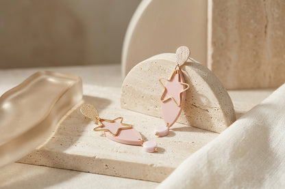 Beige Nina star geometric dangle earrings in a styled product setting