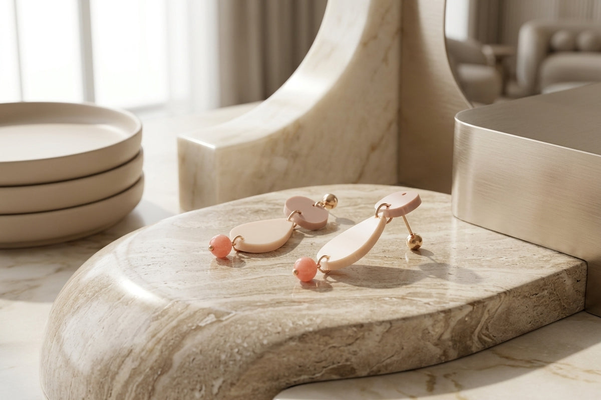 Beige Noor teardrop acrylic drop earrings in a styled product setting