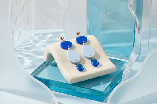 Blue Noor teardrop acrylic drop earrings in a styled product setting