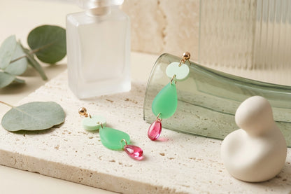 Green Noor teardrop acrylic drop earrings in a styled product setting