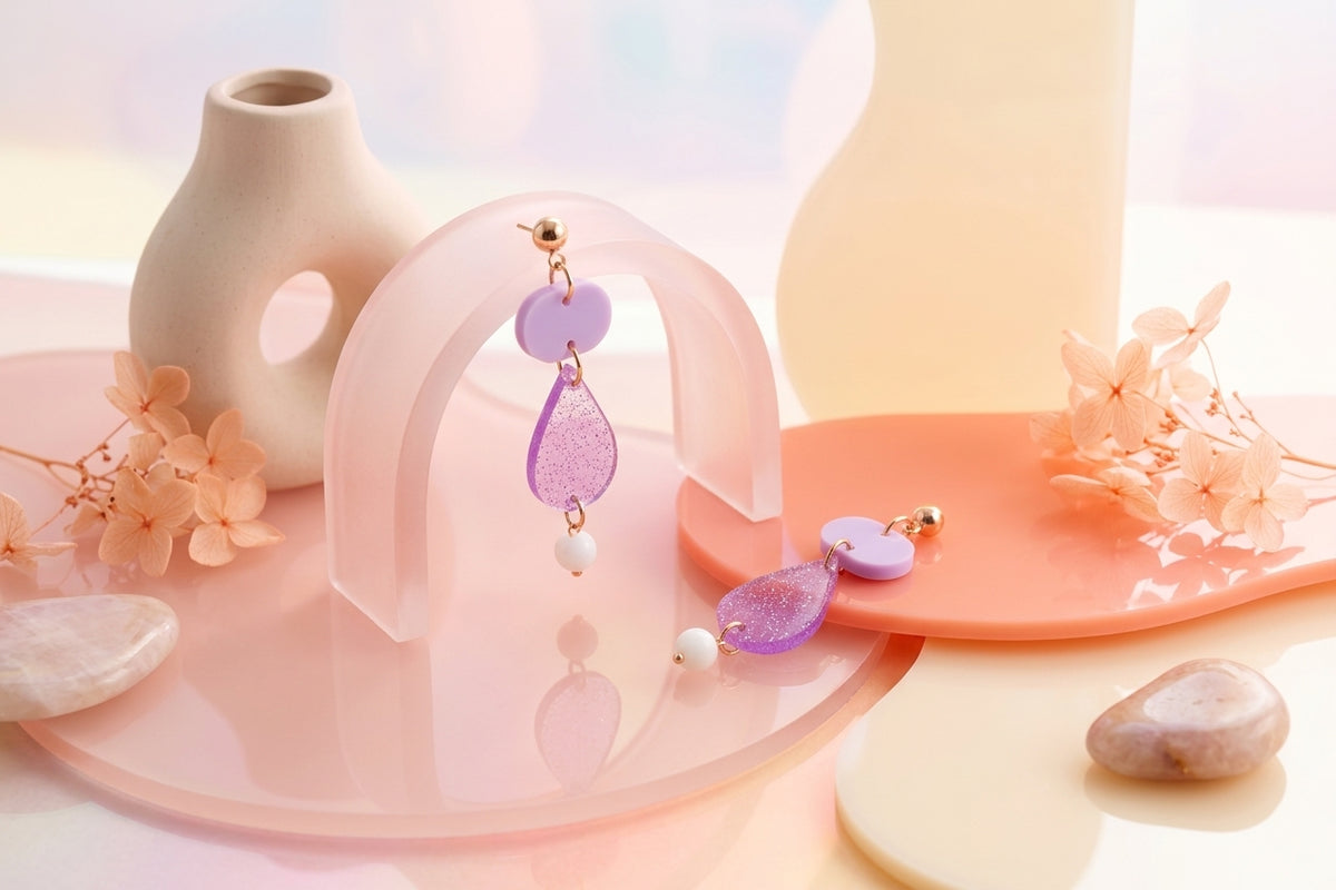 Purple Noor teardrop acrylic drop earrings in a styled product setting