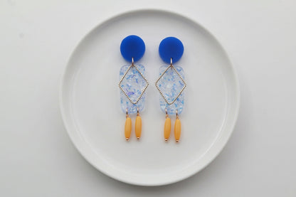 Blue Nora geometric rectangle dangle earrings arranged on a white plate