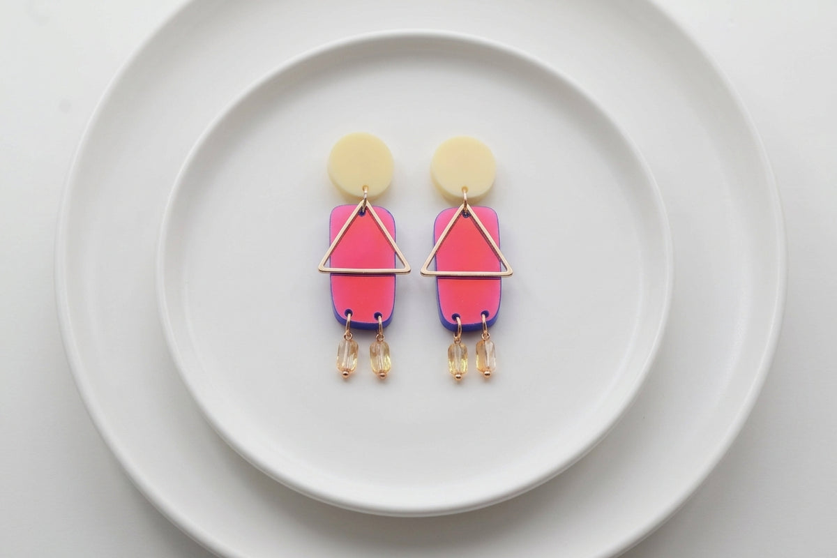 HB Nora geometric rectangle dangle earrings arranged on a white plate