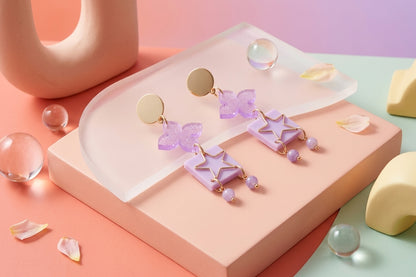 Purple Rose floral star drop earrings in a styled product setting
