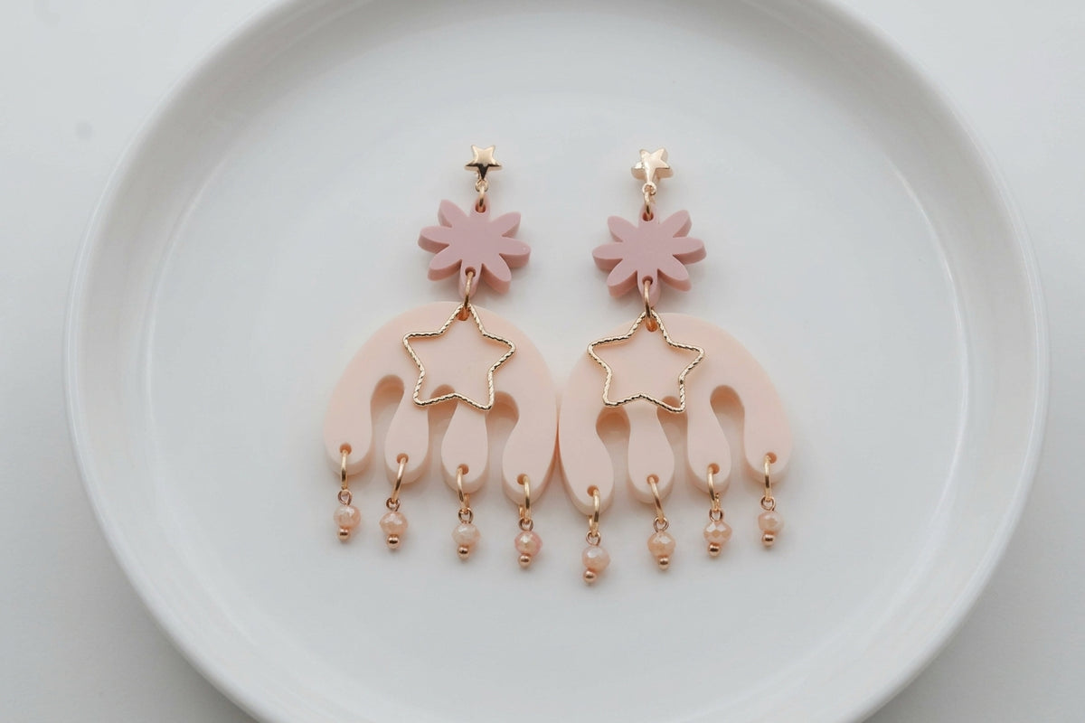 Beige Saar large flower statement earrings arranged on a white plate