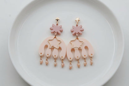 Beige Saar large flower statement earrings arranged on a white plate