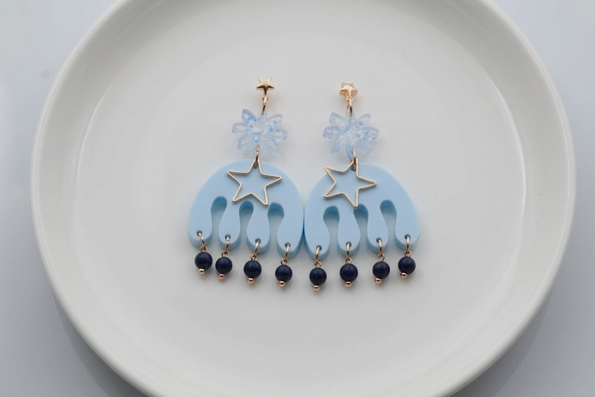 Blue Saar large flower statement earrings arranged on a white plate