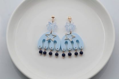 Blue Saar large flower statement earrings arranged on a white plate
