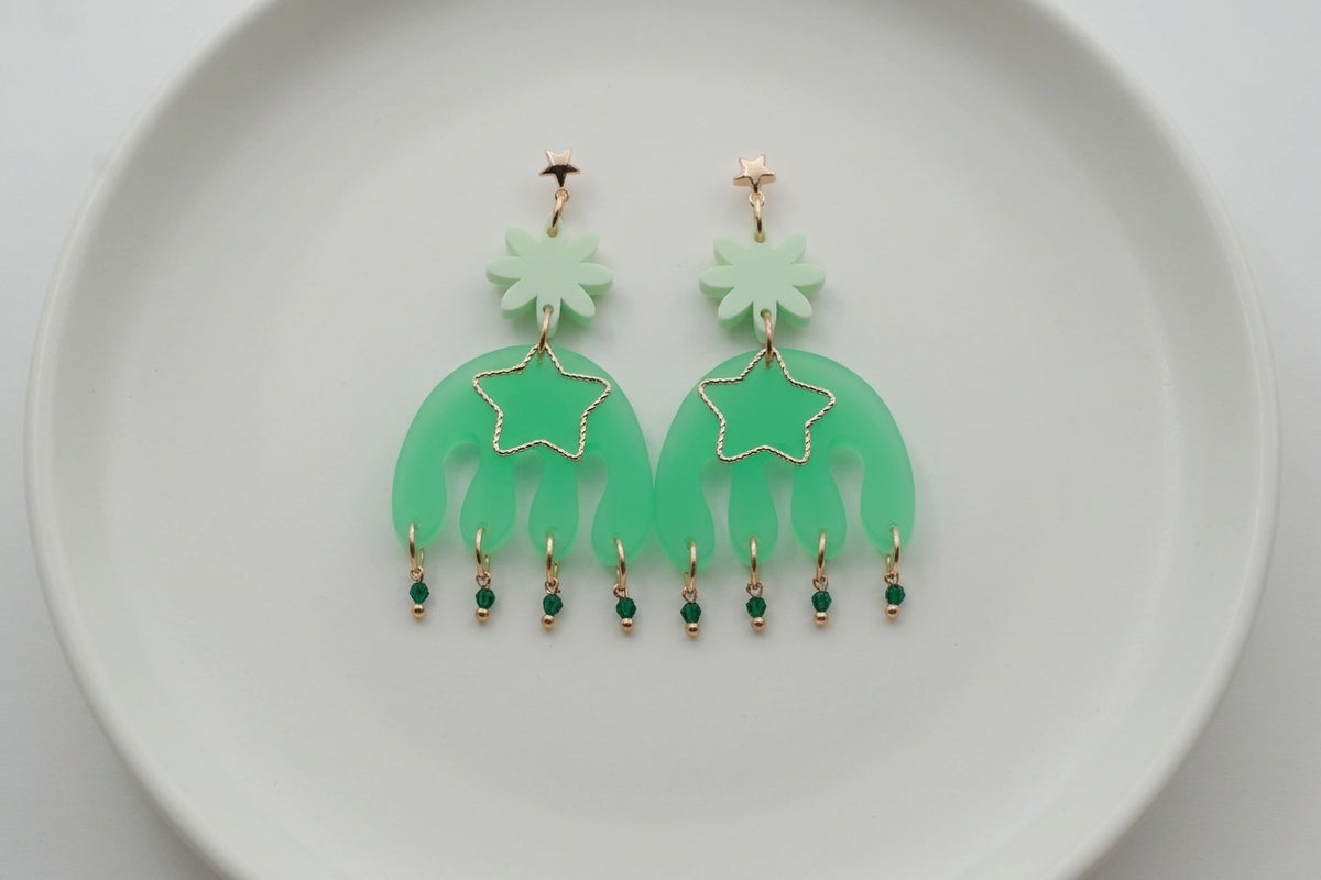 Green Saar large flower statement earrings arranged on a white plate