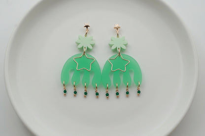 Green Saar large flower statement earrings arranged on a white plate