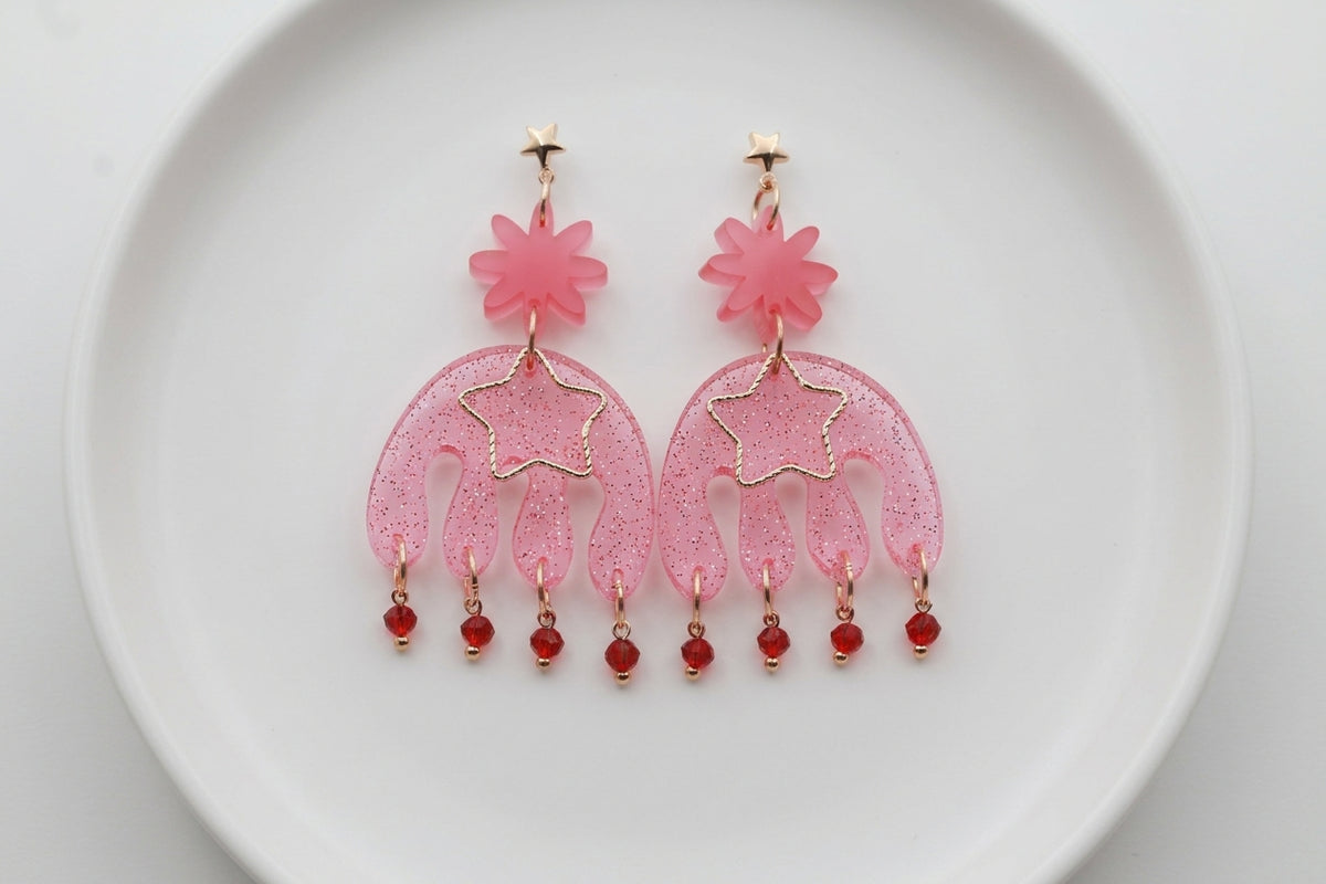 Pink Saar large flower statement earrings arranged on a white plate