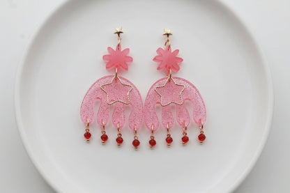 Pink Saar large flower statement earrings arranged on a white plate