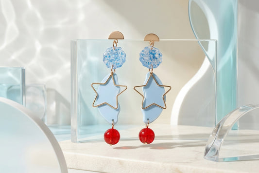 Blue Sara long star dangle earrings in a styled product setting