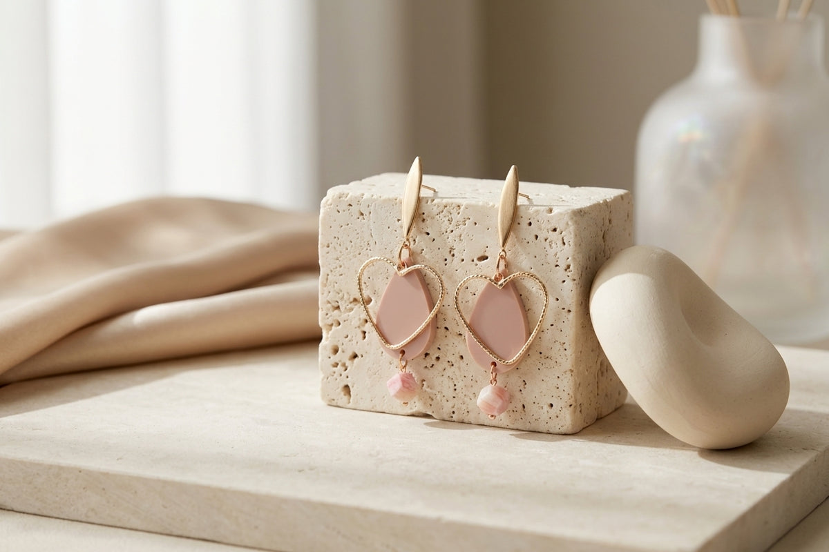 Beige Sofia heart teardrop dangle earrings in a styled product setting
