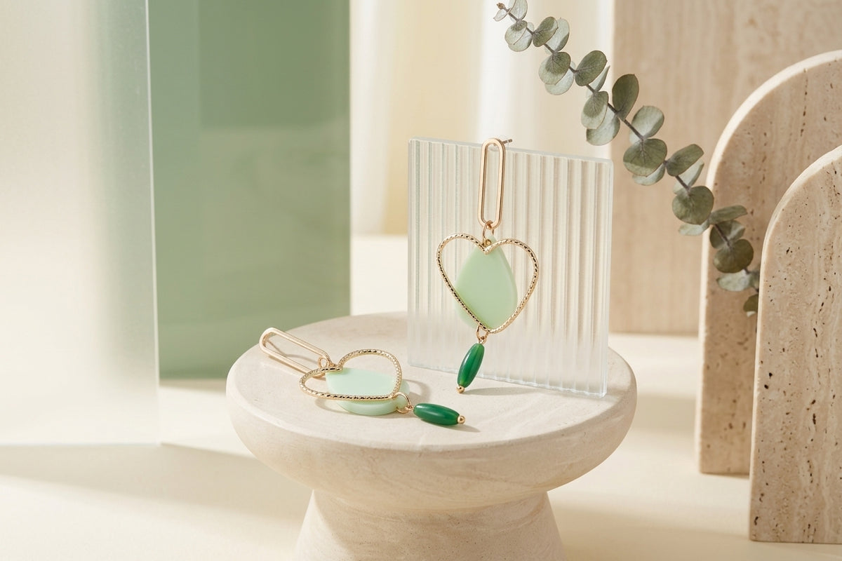 Green Sofia heart teardrop dangle earrings in a styled product setting