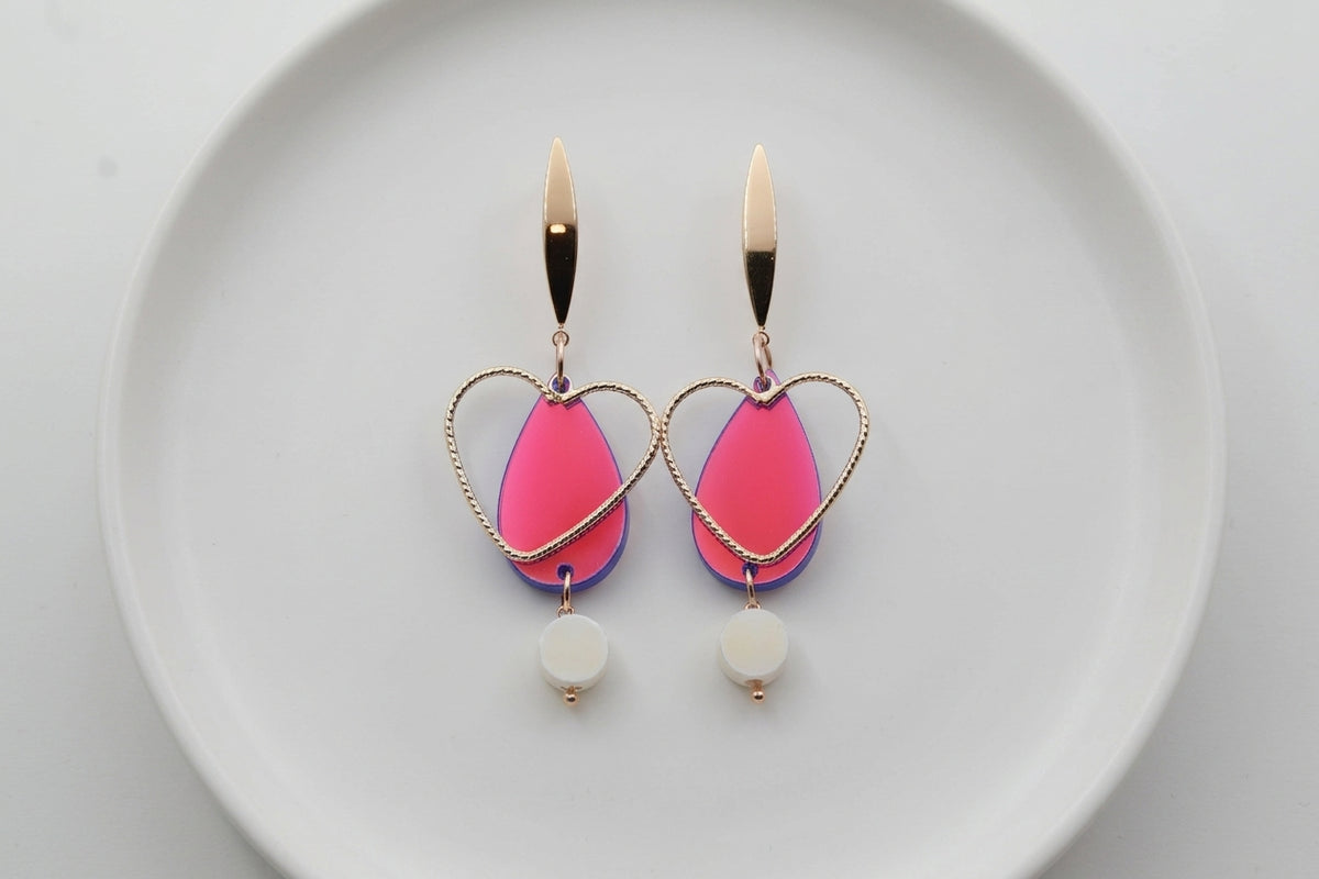 HB Sofia heart teardrop dangle earrings arranged on a white plate