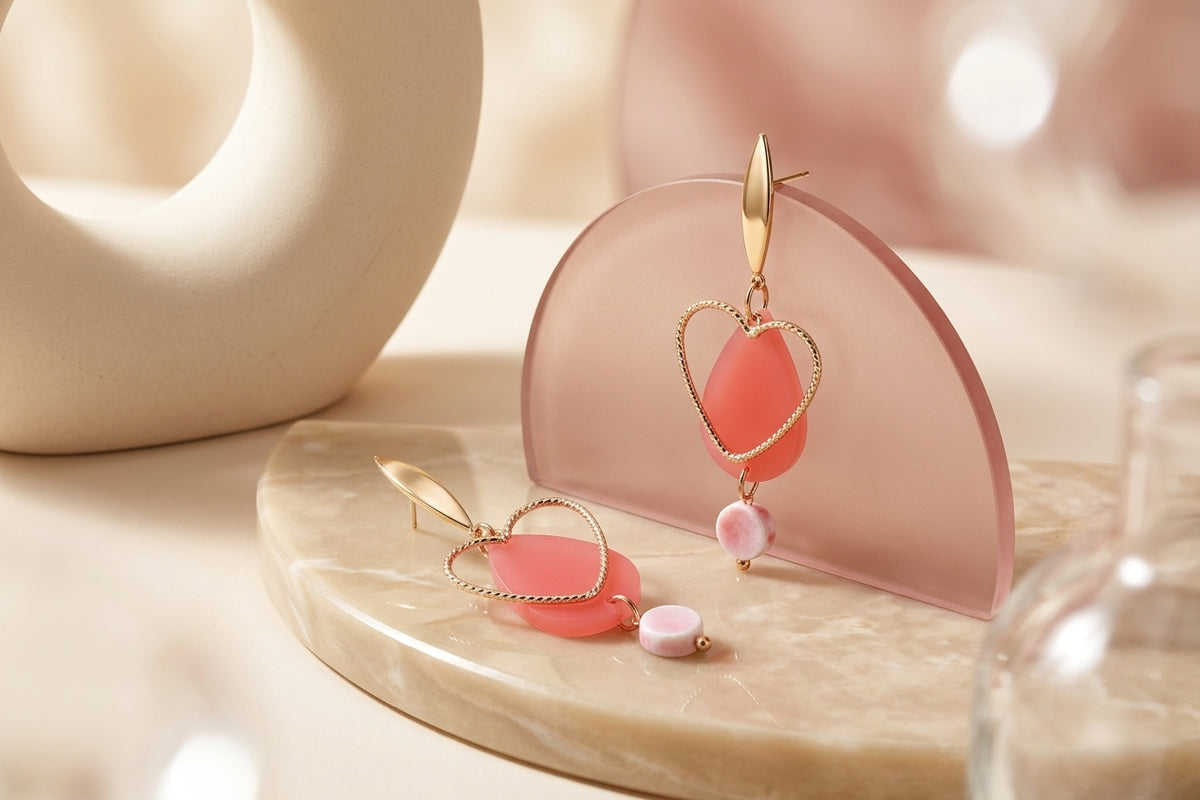 Pink Sofia heart teardrop dangle earrings in a styled product setting