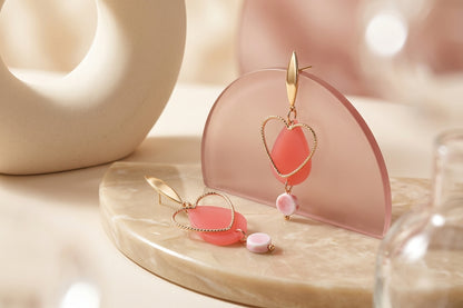 Pink Sofia heart teardrop dangle earrings in a styled product setting