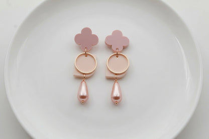 Beige Zoe floral geometric drop earrings arranged on a white plate