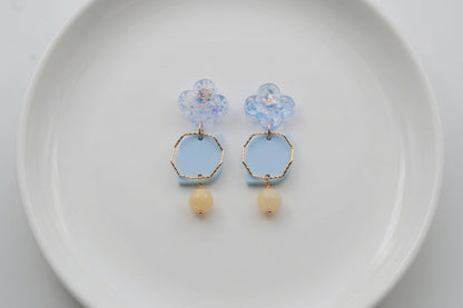 Blue Zoe floral geometric drop earrings arranged on a white plate