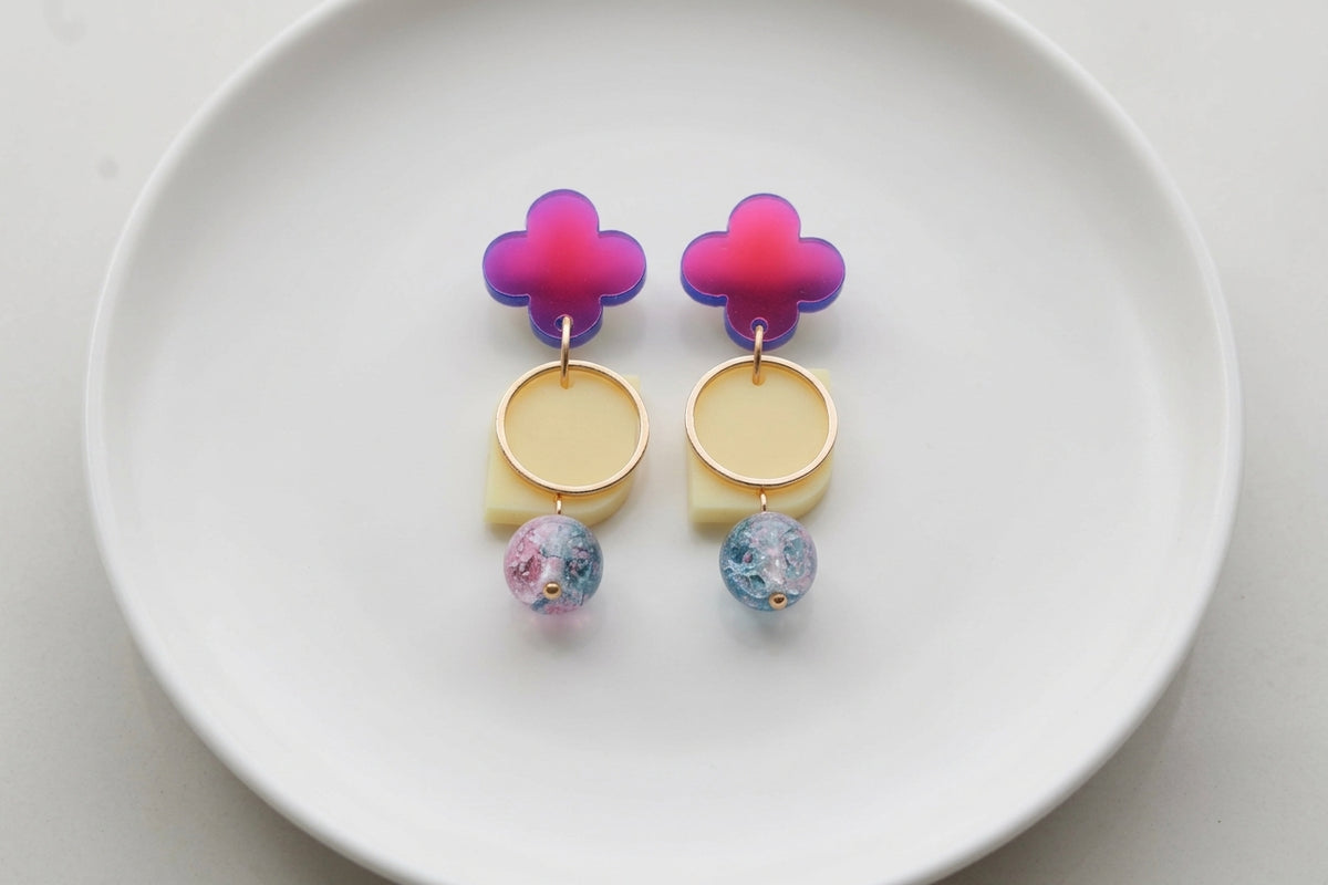 HB Zoe floral geometric drop earrings arranged on a white plate