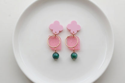 Pink Zoe floral geometric drop earrings arranged on a white plate
